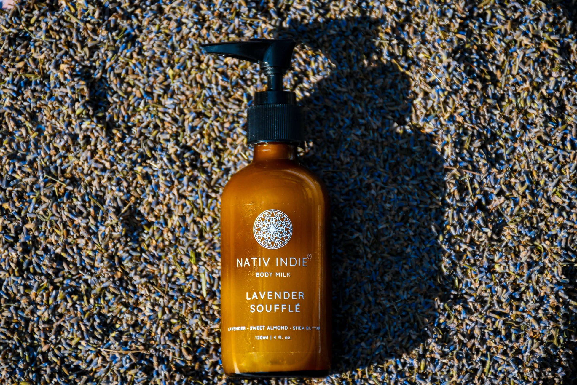 Nativ Indie Lavender Soufflé Body Milk bottle on dried lavender, featuring organic skincare and natural ingredients.